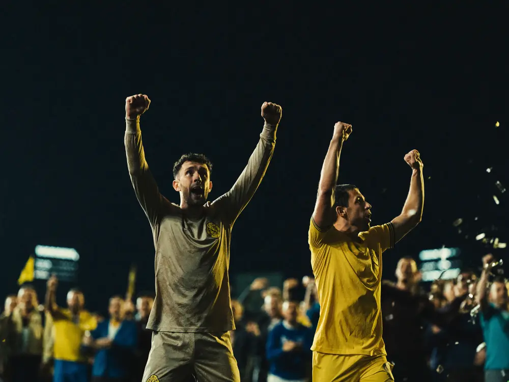 Football players celebrating a goal during a live tournament match